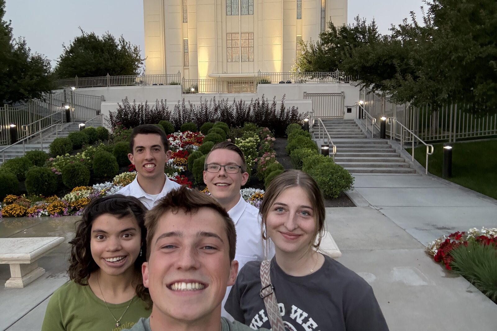 Tanner Yost and four friends outside the Rexburg Idaho Temple at dusk, the temple lit behind them.